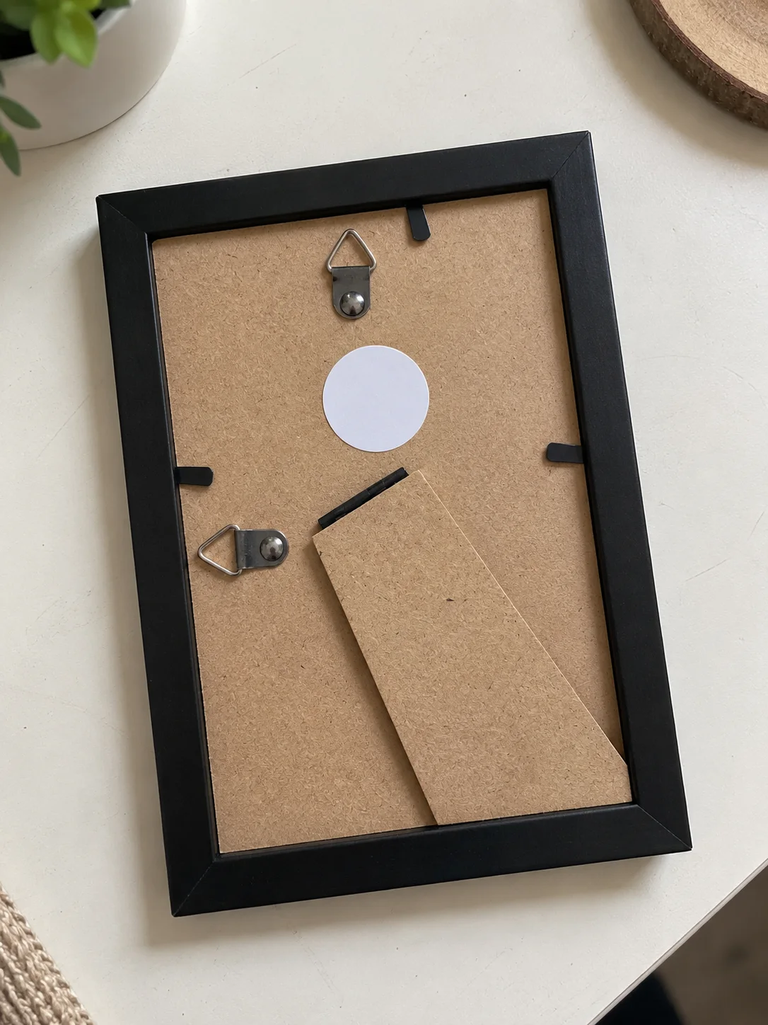 The back of the Black frame: MDF backing, triangle hook, easel leg, and the round NFC tag